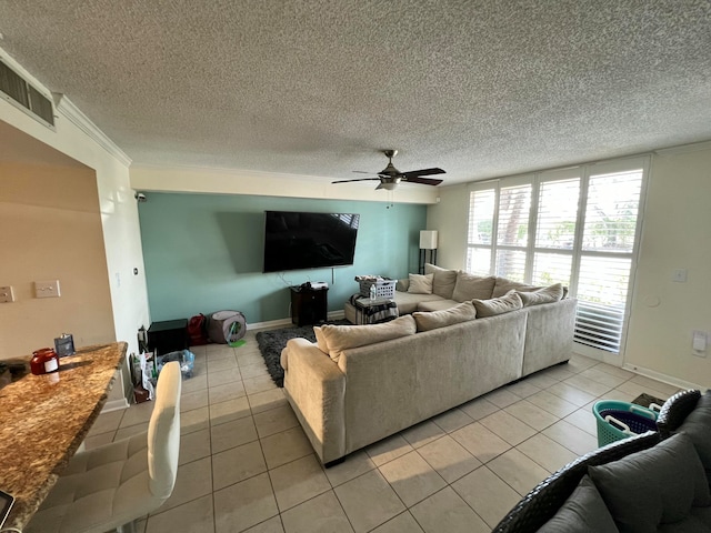 tiled living room featuring ceiling fan, crown molding, and a textured ceiling