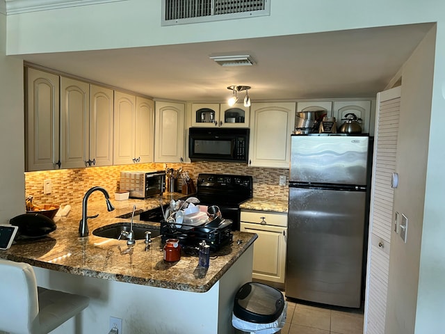 kitchen featuring kitchen peninsula, light tile patterned floors, sink, and black appliances