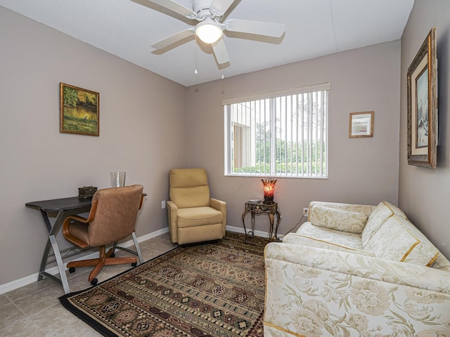 office area with light tile patterned flooring, a ceiling fan, and baseboards