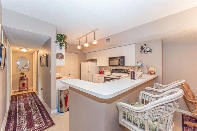 kitchen featuring white cabinetry, white refrigerator, kitchen peninsula, decorative light fixtures, and stainless steel electric stove