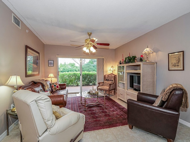 living room featuring ceiling fan, light tile patterned floors, visible vents, and baseboards