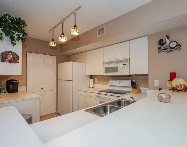 kitchen featuring light countertops, white appliances, visible vents, and a sink