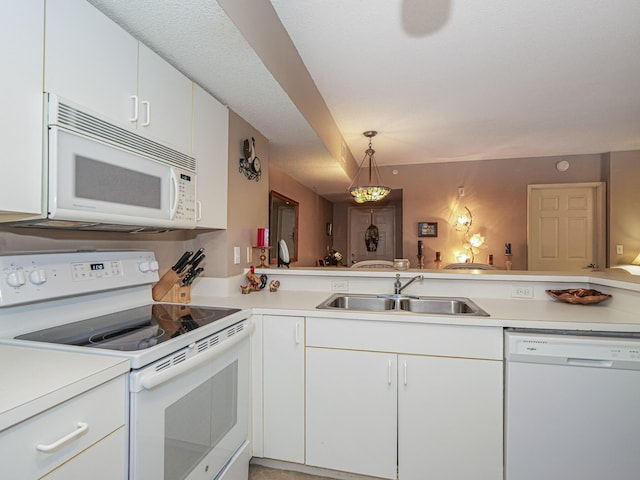 kitchen featuring white cabinets, white appliances, light countertops, and a sink