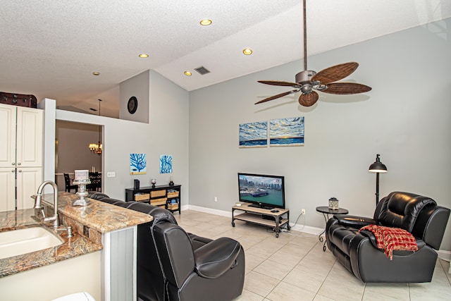 living room with ceiling fan, sink, high vaulted ceiling, and a textured ceiling