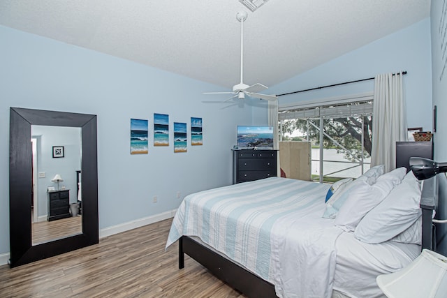 bedroom with access to exterior, wood-type flooring, vaulted ceiling, and ceiling fan