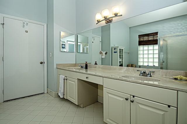 bathroom featuring tile patterned flooring, vanity, and a shower with shower door