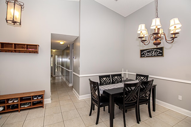 dining room featuring light tile patterned flooring, a chandelier, and a high ceiling