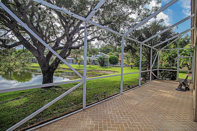 unfurnished sunroom featuring a water view