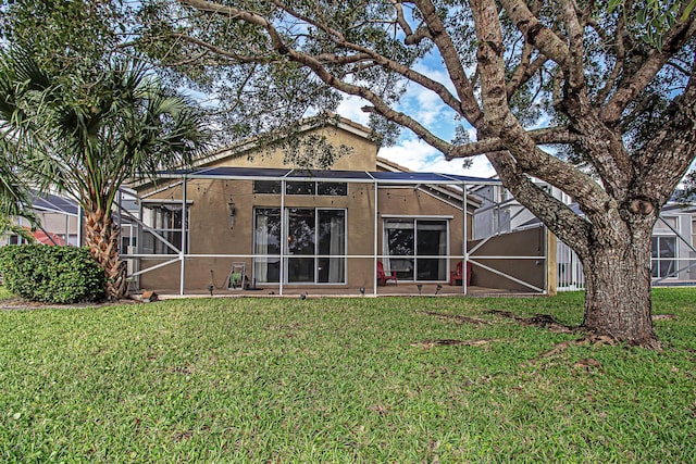 back of house with a lanai and a yard