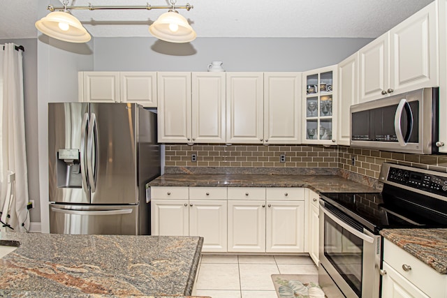 kitchen featuring white cabinets, decorative light fixtures, and stainless steel appliances