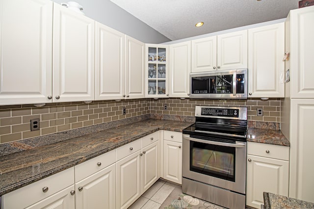 kitchen featuring light tile patterned floors, white cabinetry, a textured ceiling, and appliances with stainless steel finishes