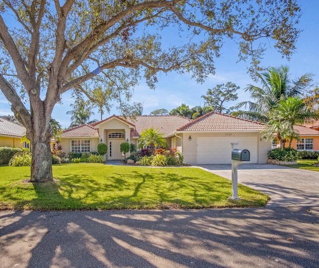 mediterranean / spanish-style home featuring a front lawn and a garage