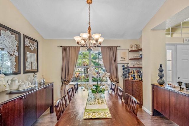 dining area featuring vaulted ceiling, an inviting chandelier, and dark wood-type flooring