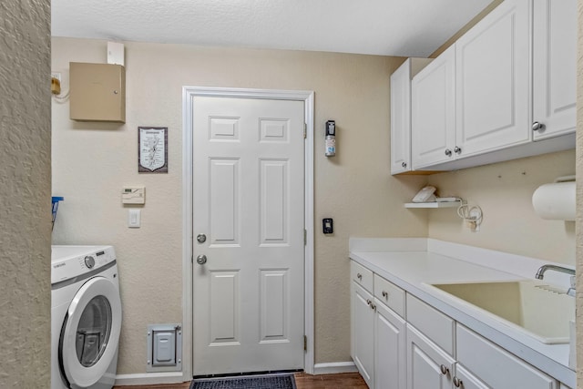 laundry area featuring cabinets, washer / dryer, a textured ceiling, and sink