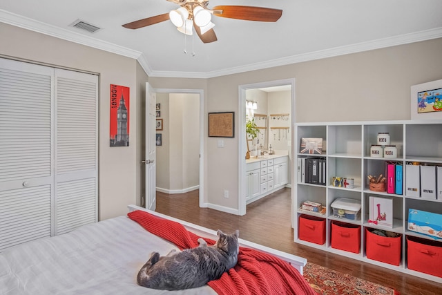 bedroom featuring ceiling fan, dark wood-type flooring, ensuite bathroom, a closet, and ornamental molding