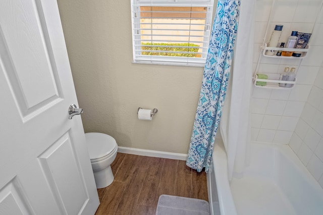 bathroom with shower / bath combo with shower curtain, wood-type flooring, and toilet