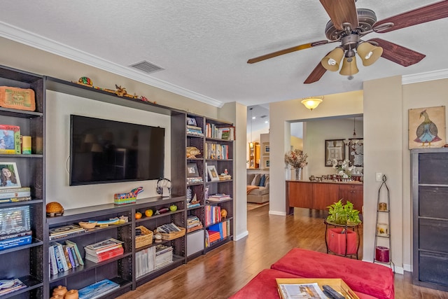 living room featuring wood-type flooring, a textured ceiling, ceiling fan, and crown molding