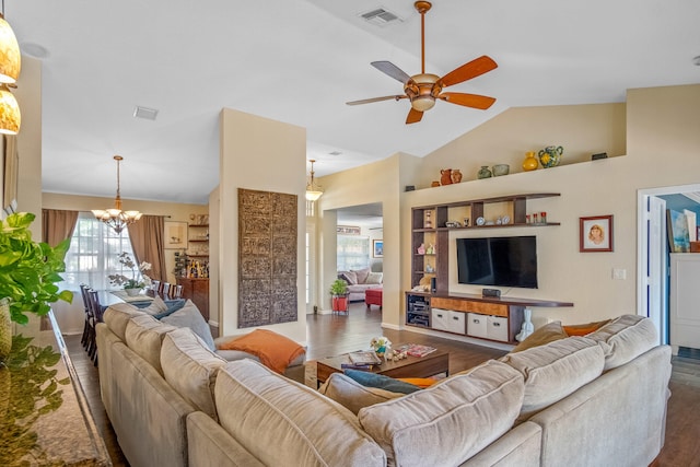 living room featuring ceiling fan with notable chandelier, dark hardwood / wood-style floors, and vaulted ceiling