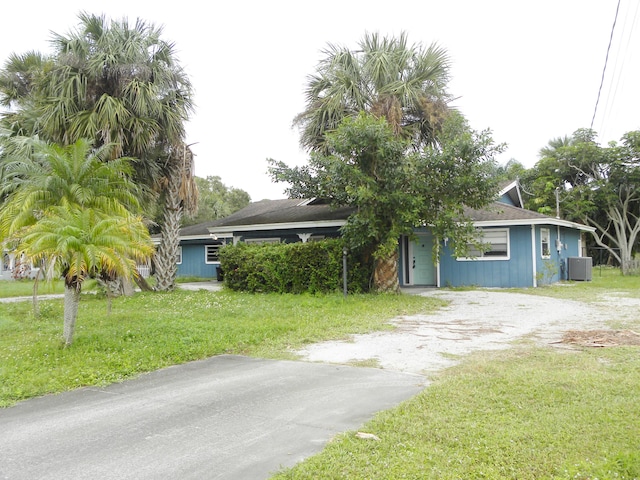 obstructed view of property with a front yard and cooling unit