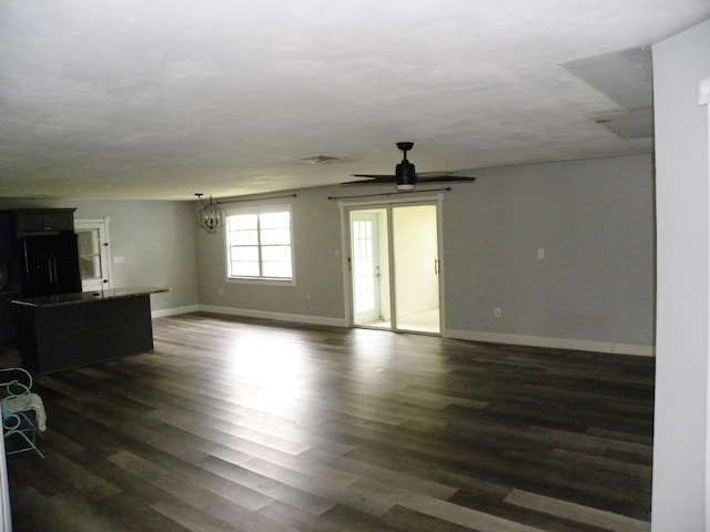 unfurnished living room featuring dark hardwood / wood-style flooring and a notable chandelier