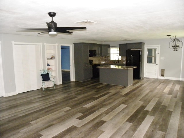 kitchen featuring dark hardwood / wood-style floors, a kitchen island, ceiling fan with notable chandelier, and tasteful backsplash