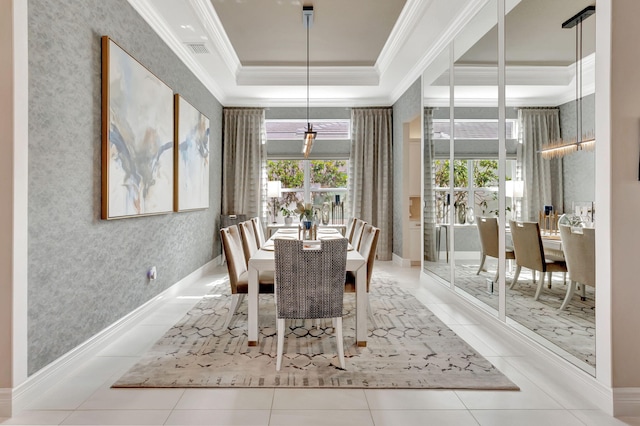 tiled dining area with a raised ceiling and ornamental molding