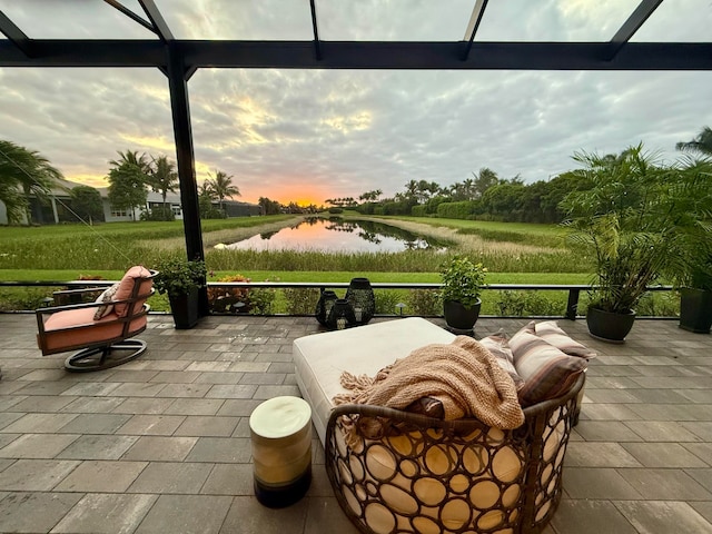 patio terrace at dusk with a lanai and a water view