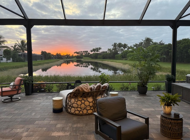 patio terrace at dusk with a water view and a lanai