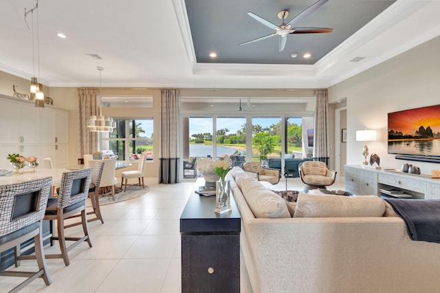 tiled living room with a raised ceiling, ceiling fan, and crown molding