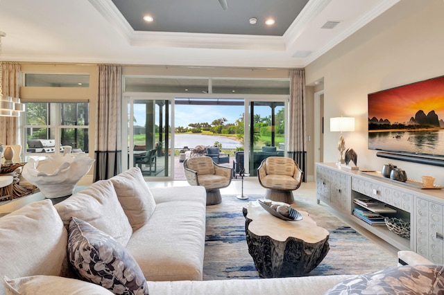 living room with crown molding, a wealth of natural light, and a tray ceiling