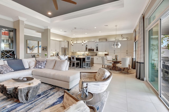 tiled living room featuring a raised ceiling, ceiling fan, and crown molding