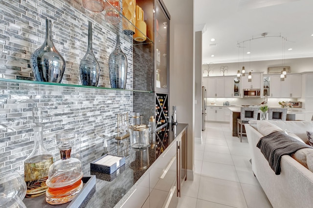 bar featuring white cabinetry, appliances with stainless steel finishes, decorative light fixtures, and ornamental molding