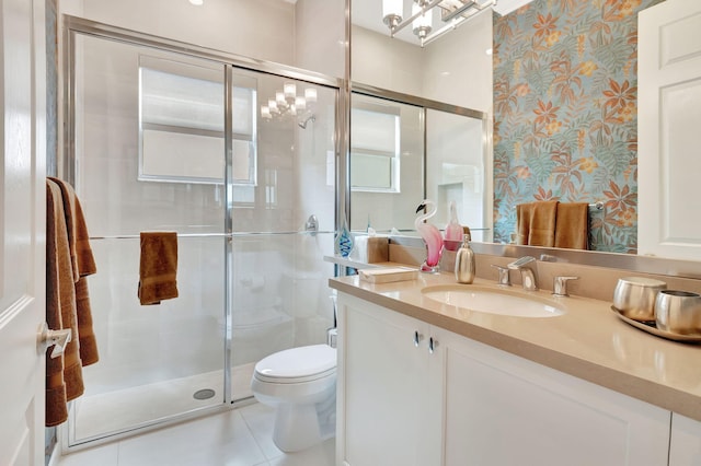 bathroom featuring tile patterned flooring, vanity, toilet, and walk in shower