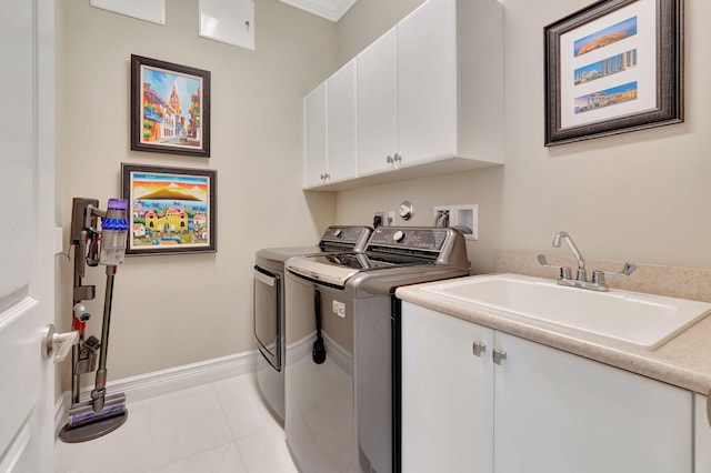 laundry area featuring cabinets, sink, washing machine and dryer, light tile patterned floors, and ornamental molding