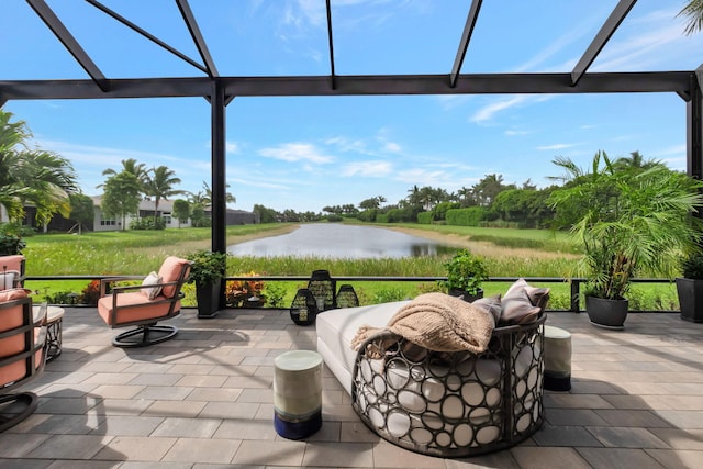 view of patio / terrace featuring a lanai and a water view