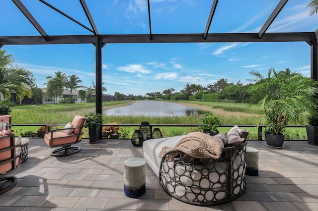 view of patio with a water view and a lanai