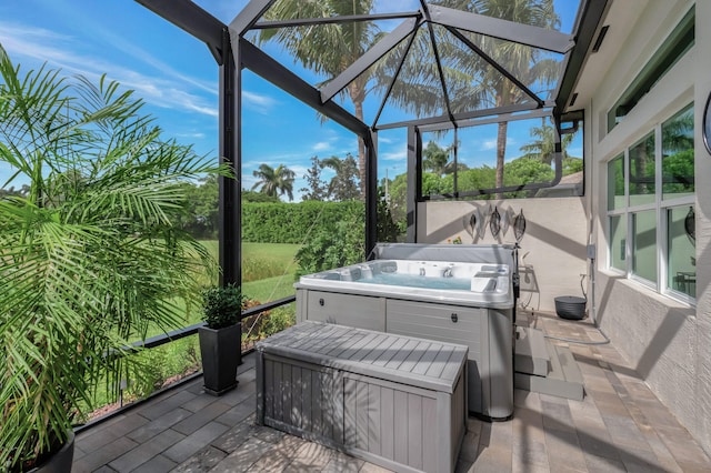 view of patio featuring glass enclosure and a hot tub