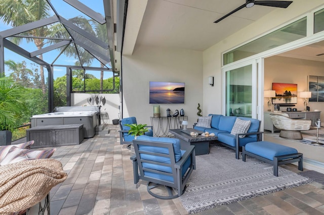 view of patio featuring outdoor lounge area, glass enclosure, ceiling fan, and a hot tub