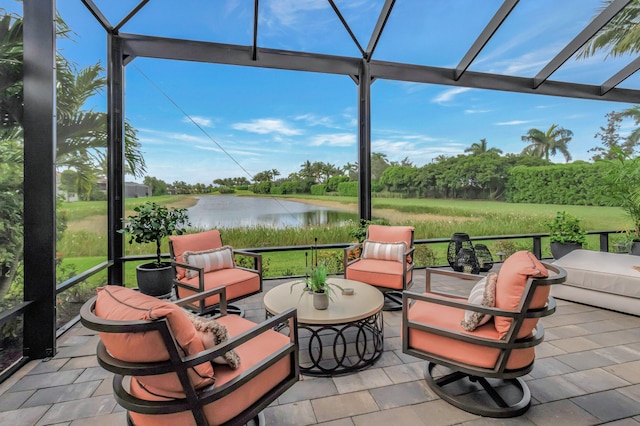 view of patio with glass enclosure, an outdoor living space, and a water view