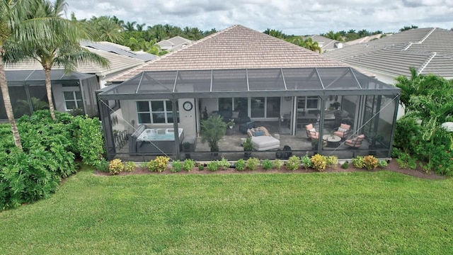 back of property featuring glass enclosure and a yard