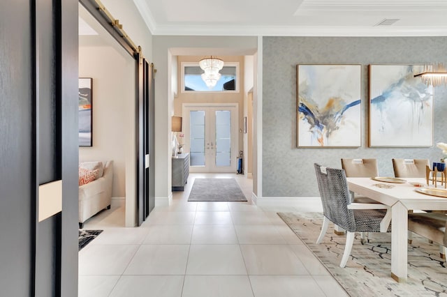 foyer featuring french doors, a barn door, a chandelier, light tile patterned floors, and ornamental molding