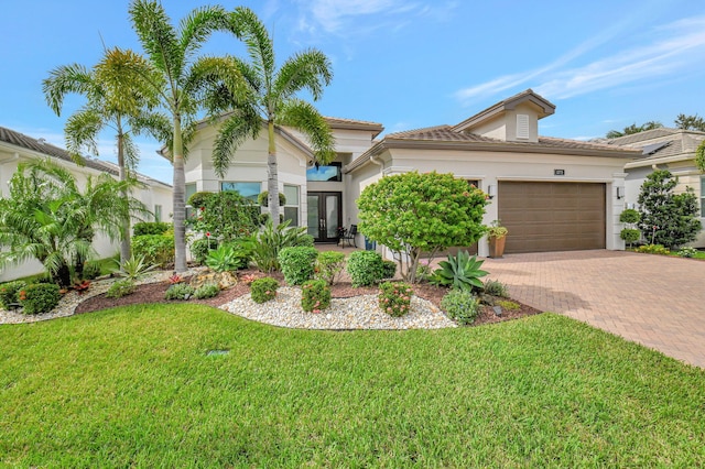 mediterranean / spanish home featuring french doors, a garage, and a front lawn