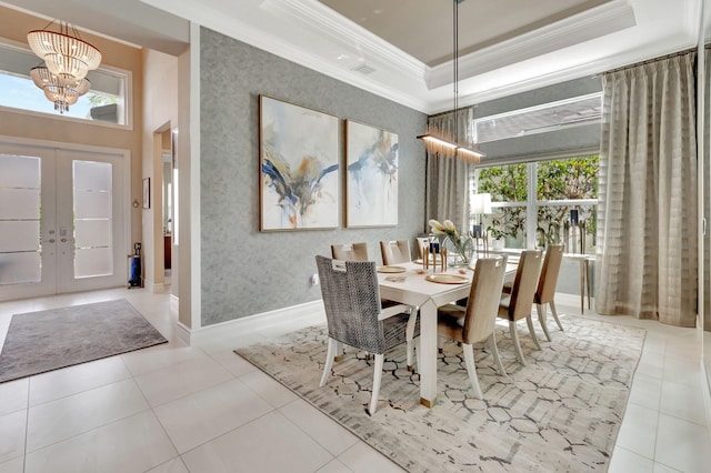 dining area featuring french doors, a raised ceiling, crown molding, light tile patterned floors, and a chandelier