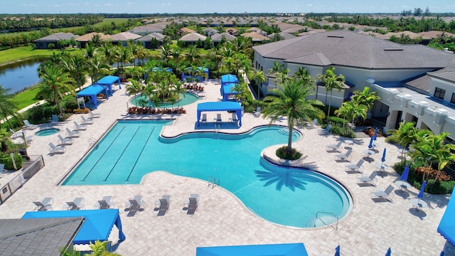 view of swimming pool with a water view and a patio area