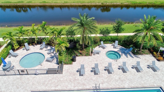 view of swimming pool featuring a water view and a patio