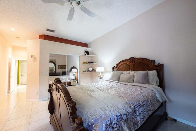 bedroom featuring ceiling fan, light tile patterned flooring, a textured ceiling, and vaulted ceiling