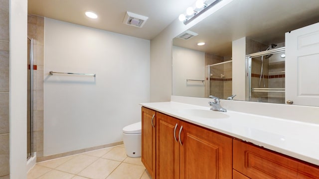 bathroom with tile patterned flooring, vanity, a shower with door, and toilet