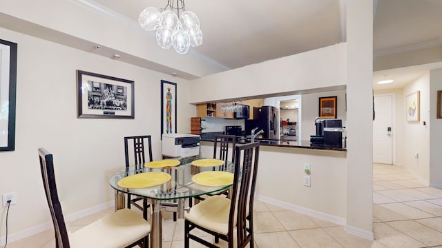 dining room with crown molding, light tile patterned floors, and a notable chandelier