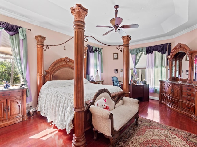 bedroom featuring hardwood / wood-style floors, ceiling fan, crown molding, and a tray ceiling