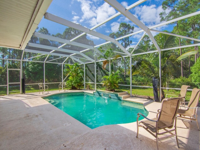 view of pool featuring pool water feature, glass enclosure, and a patio area